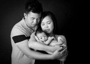 alt=black and white image couple holding baby
