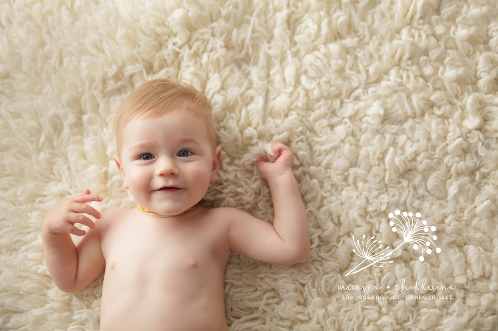 alt=Edmonton family photographers, alt=toddler smiling laying on cream rug