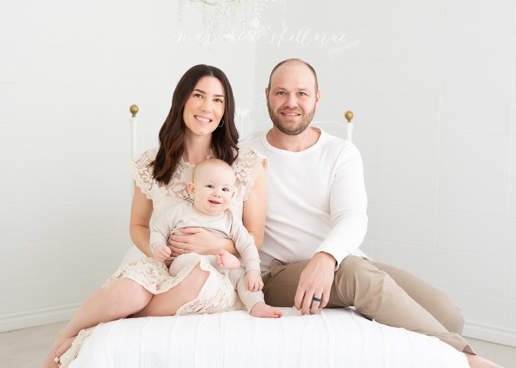 alt=family and baby shoot, alt=10 month old baby shoot, alt=mom and dad with baby on bed, alt=bright and airy family picture
