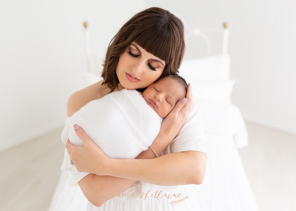 alt=high key image of mom and baby, alt=mom with newborn on light background