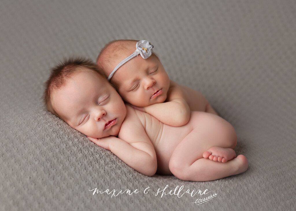 alt=Experienced newborn twins Edmonton, alt=naked newborn twins bum up, alt=newborn twins on grey blanket