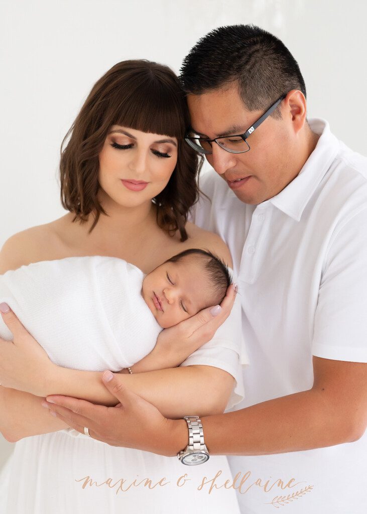 alt=high key image of mom, dad and baby, alt=mom and dad with newborn on light background
