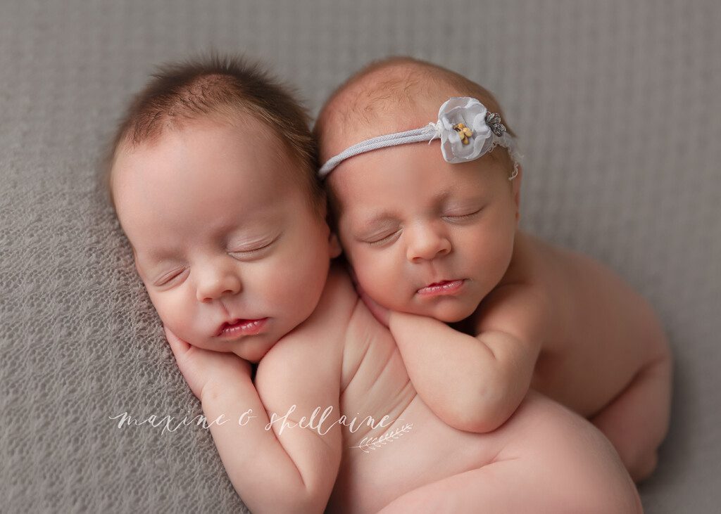 alt=Experienced newborn twins Edmonton, alt=naked newborn twins bum up, alt=newborn twins on grey blanket